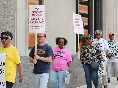 A coalition of activists protests outside the Detroit Water & Sewerage Department’s office in downtown Detroit on Friday, June 6, 2014.