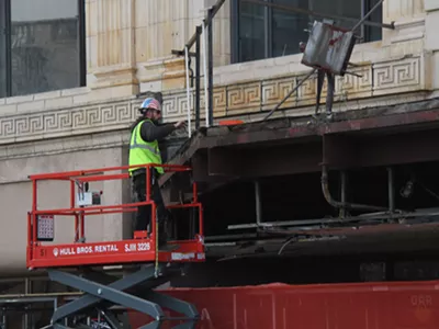 A construction worker removing the final pieces from the historic Fillmore marquee.