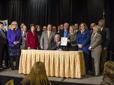 This photo is from an earlier event in Grand Rapids, where Gov. Snyder signed a bill appropriating $28 million in short-term aid for the people of Flint. But, just like this Monday's ovation, Grand Rapids-area power brokers just can't stop standing up for Snyder.