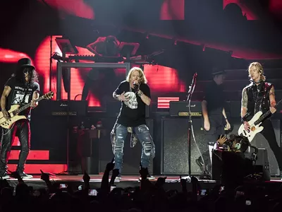Duff McKagan, left, Axl Rose, and Slash at the "Not In This Lifetime..." tour opener at Ford Field in Detroit on Thursday.