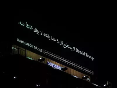 The billboard says, "Donald Trump: He can't read this, but he is afraid of it."