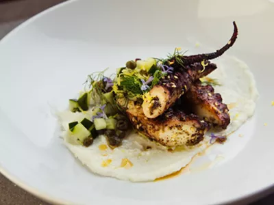Za'atar-rubbed octopus with garlic, cucumber, and fresh herbs.