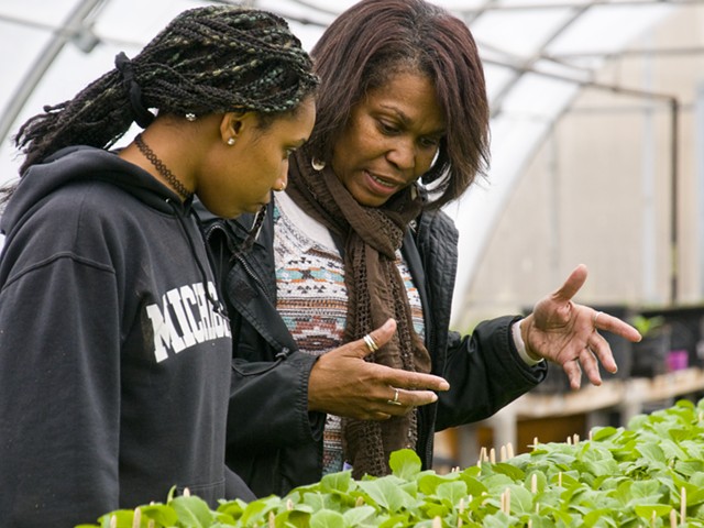 Nefer Ra Barber working with a student in a hoophouse that's used for the EAT program at Earthworks program.
