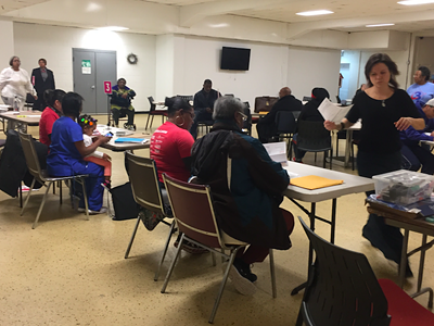 Volunteers help Detroit residents facing tax foreclosure apply for assistance to stay in their homes.