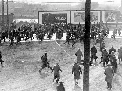 Demonstrators on Miller Road outside of the Rouge Plant flee as tear gas and bullets are released on them by Dearborn Police and Ford Servicemen during the 1932 Ford Hunger March.