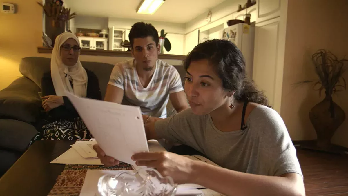 Image: Assia Boundaoui shows FBI documents to her family in The Feeling of Being Watched.