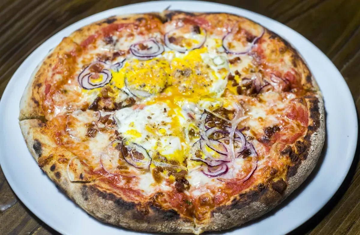Image: Fox Hollow Farm pizza with egg, pancetta, and red onion.