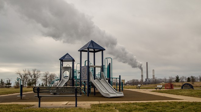 Playground in William C. Sterling State Park with billowing smokestack in the background.