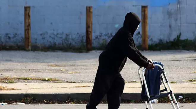 A man pushes a walker down Peterboro Street in Detroit.