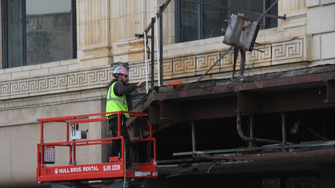 A construction worker removing the final pieces from the historic Fillmore marquee.