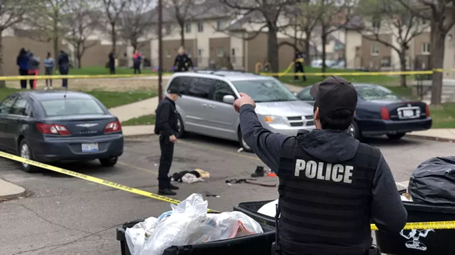 Police cordoned off the shooting scene in the parking lot of the Brewster housing complex.