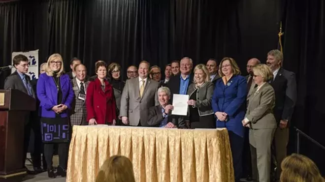 This photo is from an earlier event in Grand Rapids, where Gov. Snyder signed a bill appropriating $28 million in short-term aid for the people of Flint. But, just like this Monday's ovation, Grand Rapids-area power brokers just can't stop standing up for Snyder.