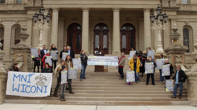 Bearing banners and signs, activists made quite a show of delivering a massive petition against the water giant's plans to pump more out of Michigan.