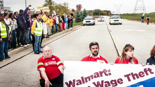 Wage theft protesters stage a sit-down protest to block the entrance of the Walmart distribution center in Elwood, Ill.