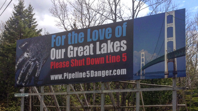 Billboards demanding the shutdown of Line 5 appeal to motorists on both sides of the Mackinac Bridge.
