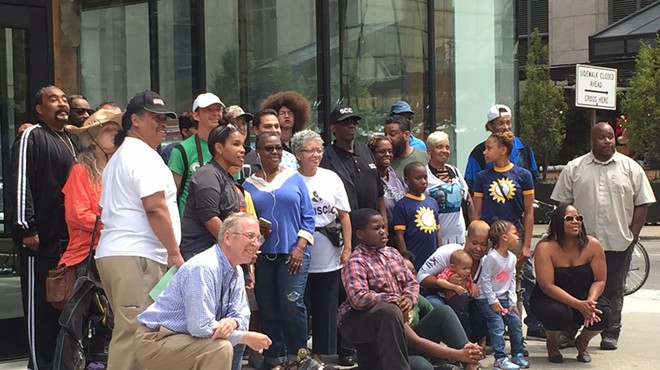 Longtime Detroiters pose for photo in front of building where racially controversial Bedrock ad was taken down.