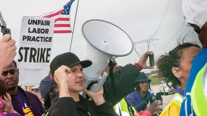 Striking workers and supporters from an Illinois Walmart distribution center march against unfair labor practices, including wage theft, in 2012.