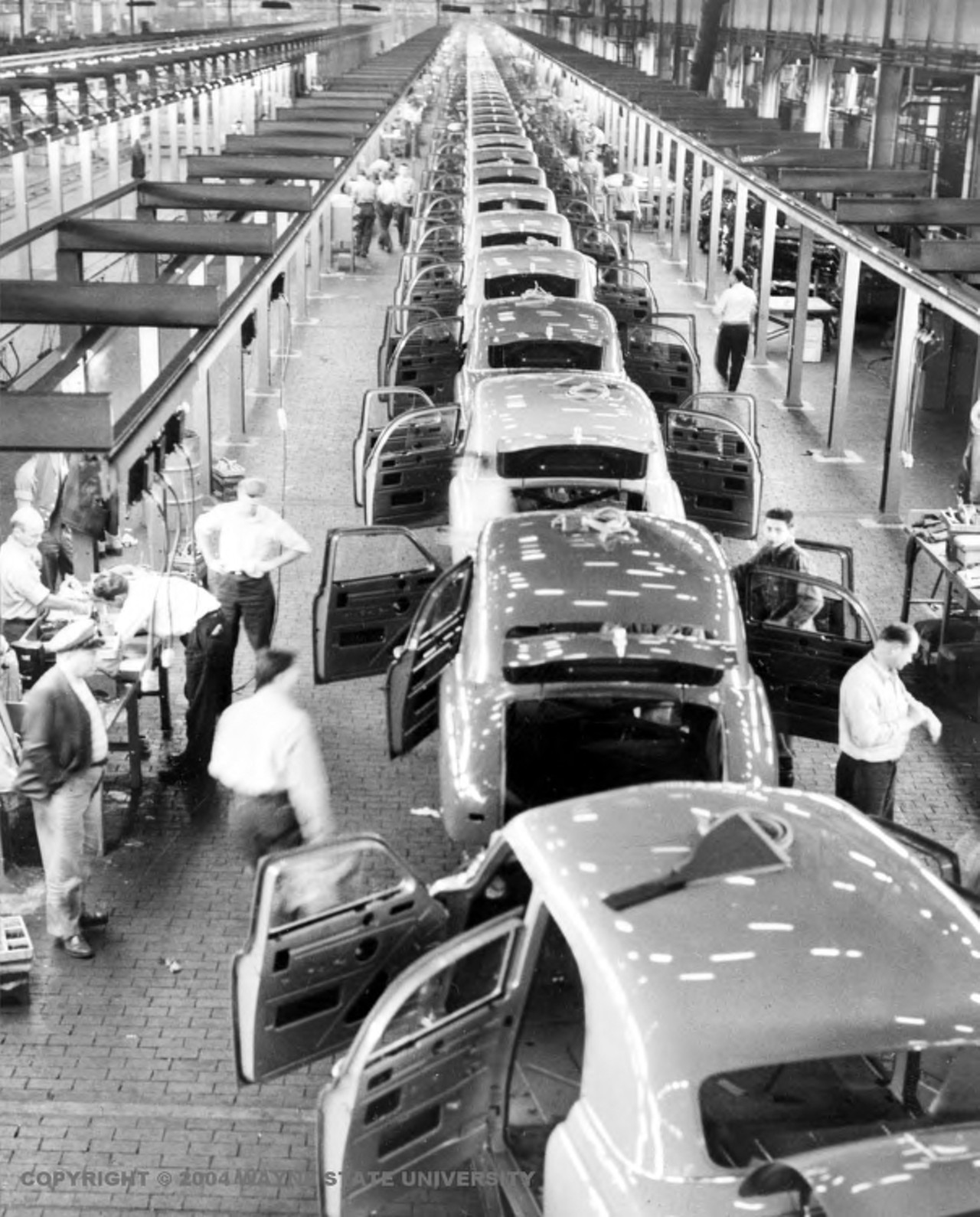 1940s - Kaiser-Frazer Motor Car Company in Willow Run
Just finishing up an assembly line of partially completed cars&#133; and counting the minutes until lunch (yeah, we&#146;re looking at you, guy on the right).