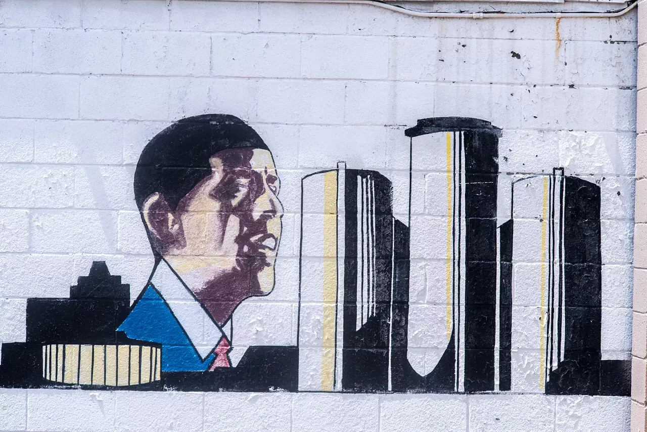 Vergara shot this image in 2014. It appeared on a wall next to a party store at Robson and Fenkell on Detroit's west side. It localizes the national leader with the inclusion of a local landmark.