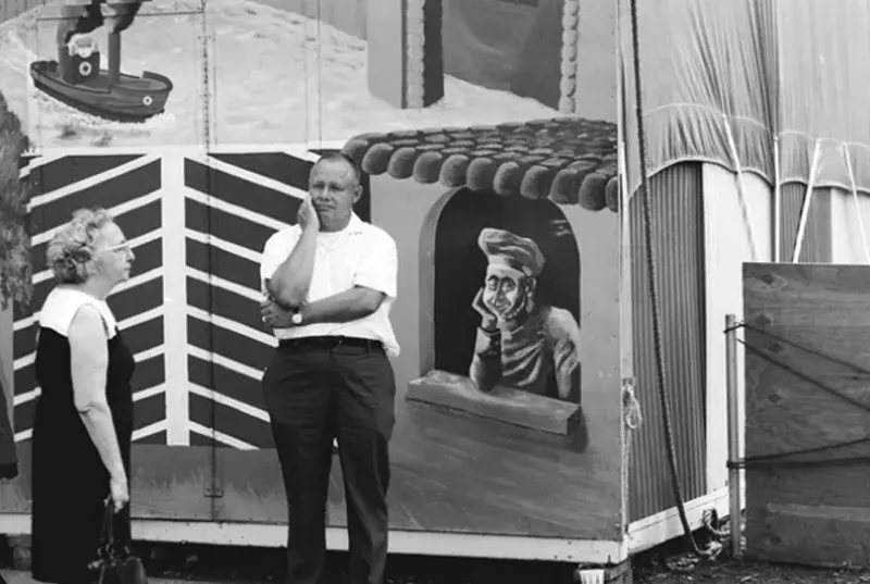 Man holding face at fair - "You have to know what you're shooting so you have to know what's happening around you and be able to put together what's happening with the context of the environment."
