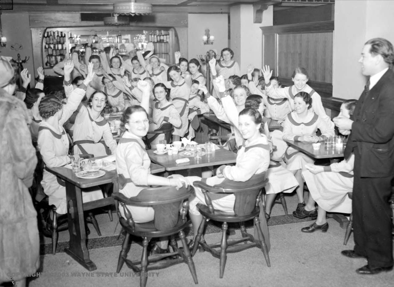 1930s | Striking restaurant workers, some holding up a hand or fist, pose for picture, during sit-down strike against Stouffer Restaurant.