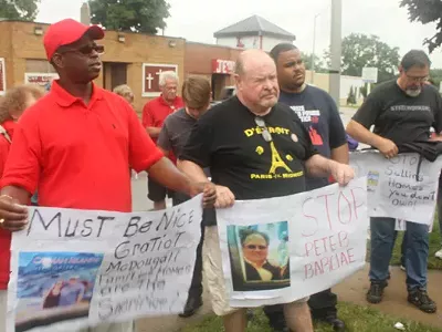 Photo cutline: Representatives from the Detroit Eviction Defense and Detroit Residents protested outside a Singapore-based real estate firm’s office in Pontiac on July 24, 2013, arguing for certain home listings to be removed. (Courtesy Detroit Eviction Defense)