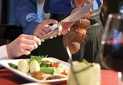 A server cuts picanha (sa Brazilian rump roast) at Gaucho Brazilian Steakhouse. - MT Photo: Rob Widdis