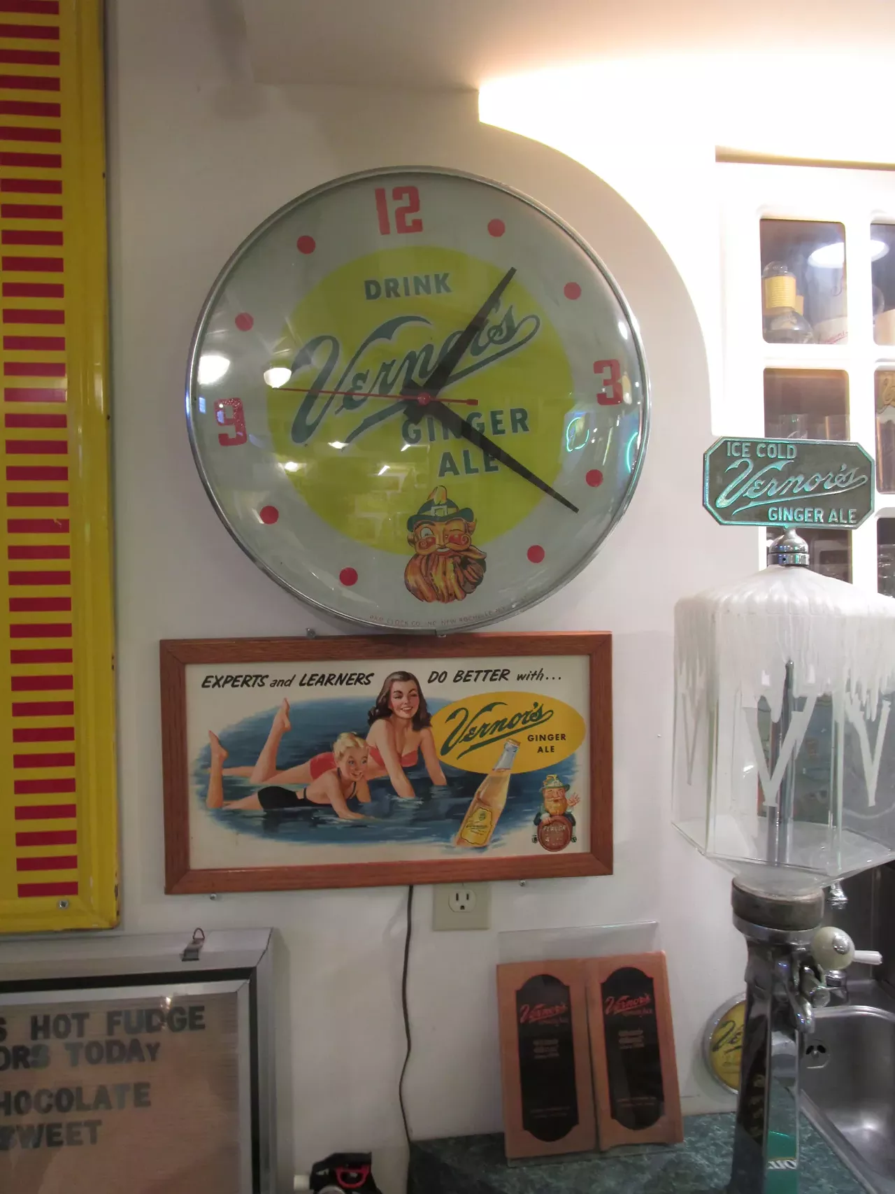 The clock shows a winking gnome, and the ad has an unusual rhyme about "Experts and learners" doing better with Vernor's.