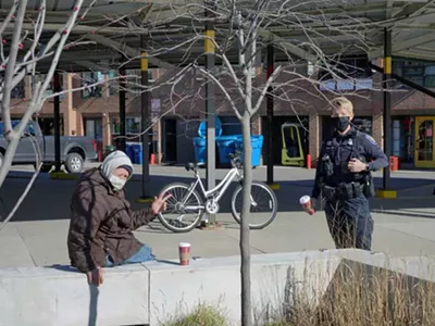 An Ann Arbor police officer speaks with a homeless man.