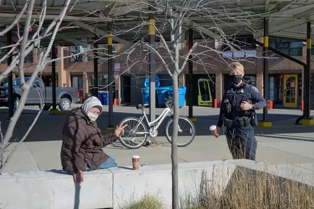 Image: An Ann Arbor police officer speaks with a homeless man.