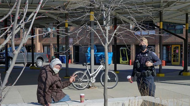 An Ann Arbor police officer speaks with a homeless man.