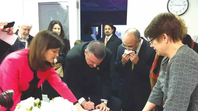 James Ryder, 48, and Frank Colasonti, 61, the first same-sex couple married at Oakland County Circuit Court Saturday, March 22, make it official with County Clerk Lisa Brown and their two witnesses, Jan Stevenson, publisher of Between the Lines, and Susan Horowitz.