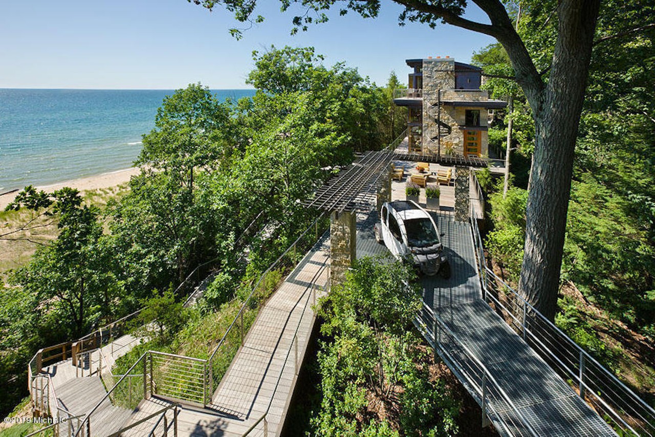 Exterior, horizontal, overall view of main house with deck, bridge and stairway to Lake Michigan from upper deck of south pod. Electric car parked on bridge is the transportation to garage 1/4 mile away on steel bridge, Byker residence, Whitehall, Michigan; Jeff Visser Design; Rock Kauffman Design; Scott Christopher Homes