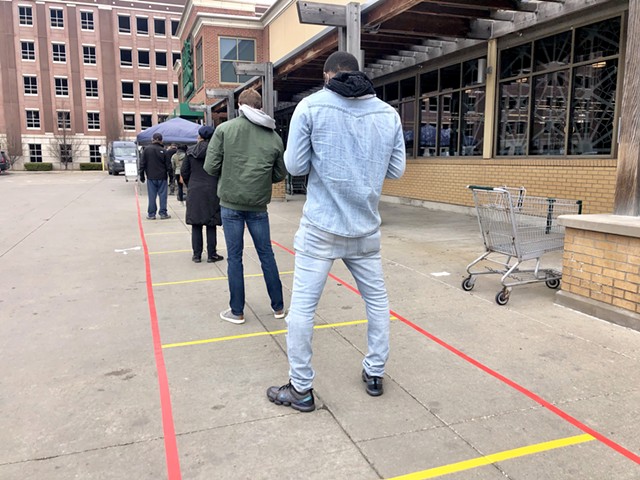 Social distancing markers guide an overflow line outside the Detroit Whole Foods store.