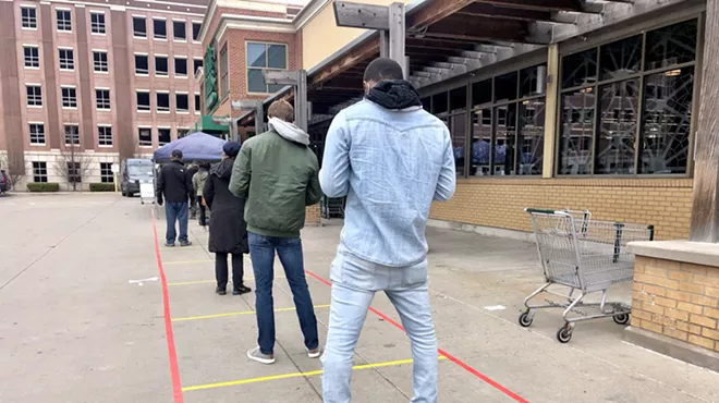 Social distancing markers guide an overflow line outside the Detroit Whole Foods store.