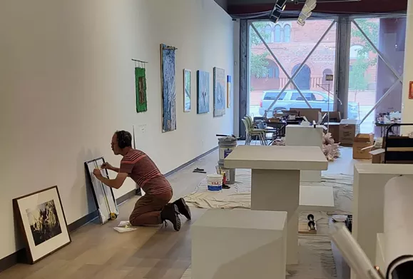 A worker puts the finishing touches on the Detroit Artists Market ahead of its first exhibition since it was remodeled.