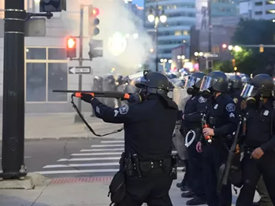 Detroit police officer fires at protesters.