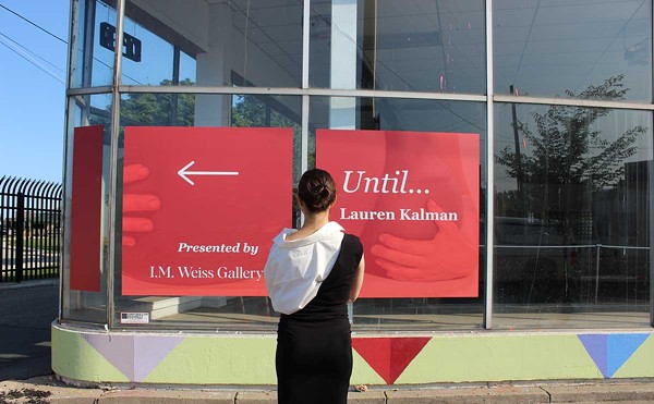 I.M. Weiss Gallery director Isabelle Weiss stands in front of a wayfinding sign for her latest exhibition in Stanton Yards.