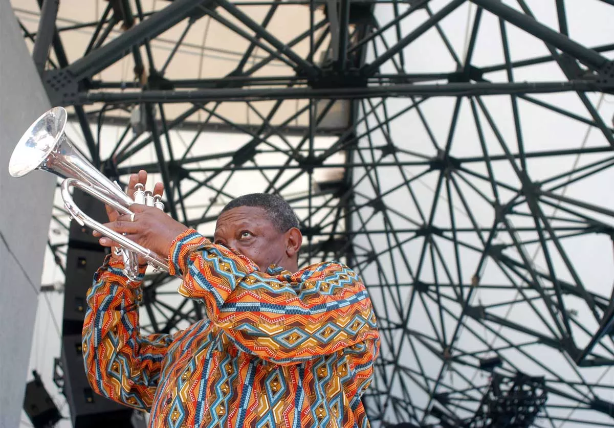 Image: Hugh Masekela, of South Africa, warms up before performing at the Concert of Colors Saturday, July 20, 2002, at Chene Park in Detroit.