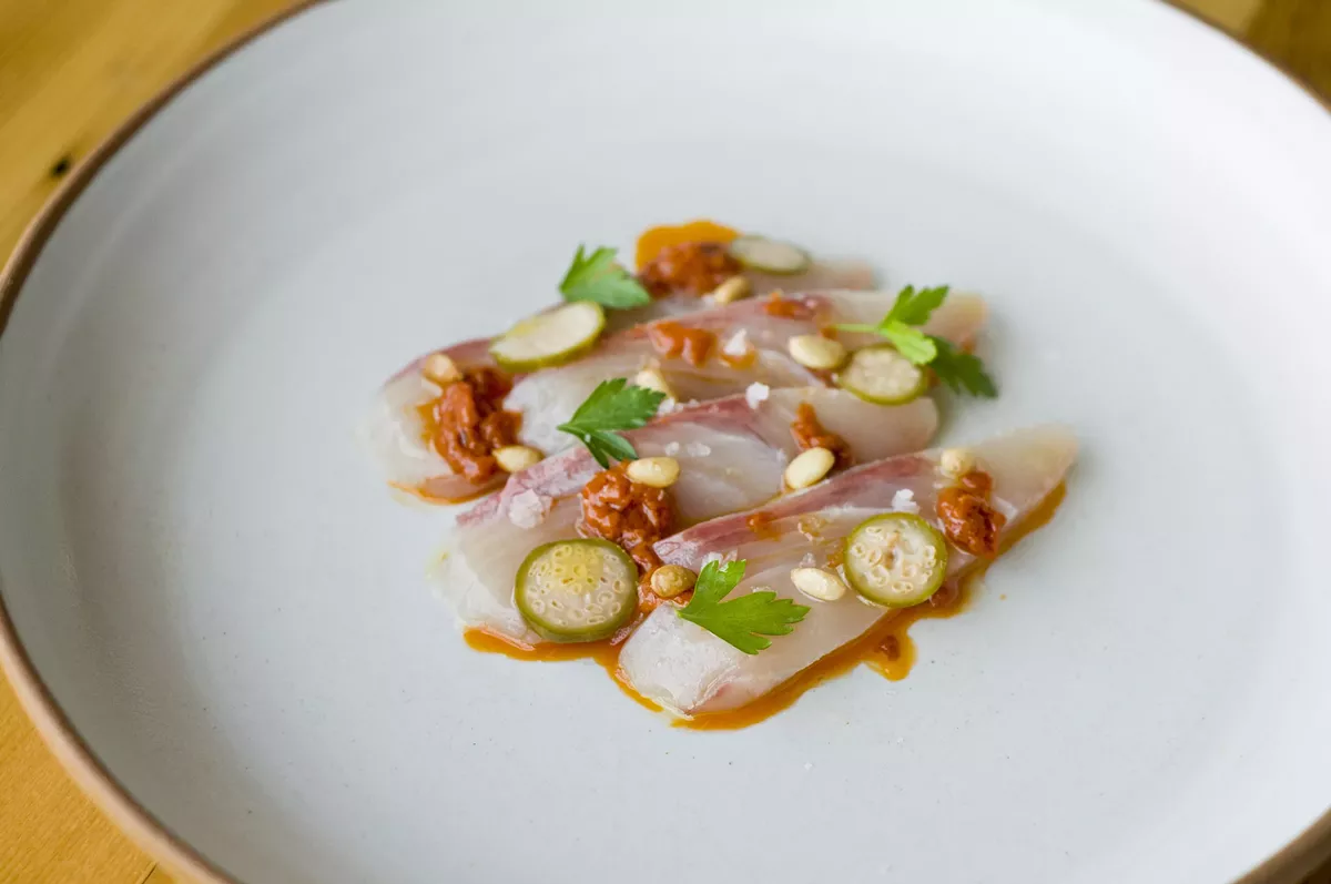 Image: Hamachi with calabrese chili, pine nut, and caperberries.