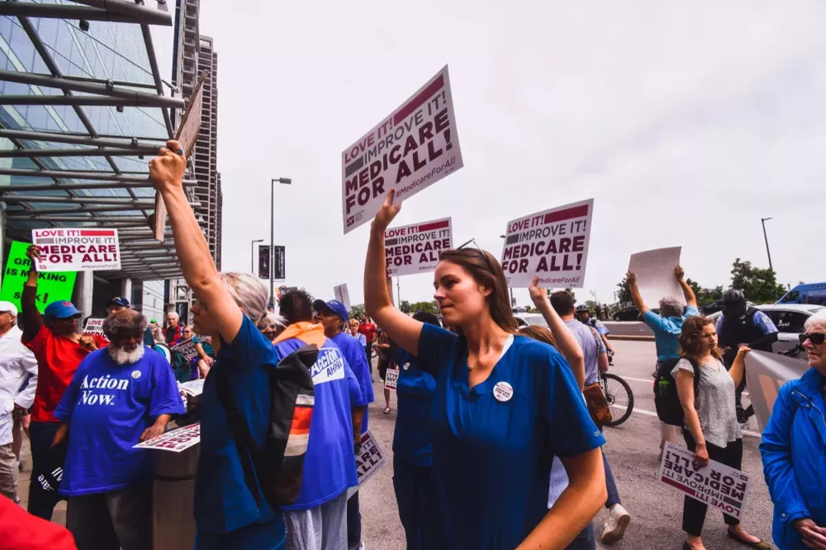 Image: A group of people gather in Chicago in 2019 for the first ever Medicare For All Rally led by Bernie Sanders.