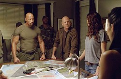Dwayne Johnson (left) and Bruce Willis are held prisoner by the military-Hollywood complex.