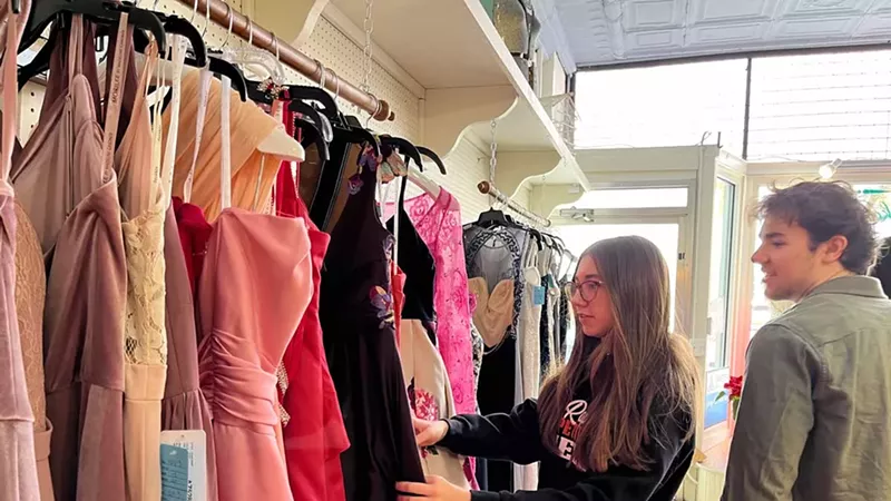 Elk Rapids High School Eco Club members Kaylee Lemmien and Gabe Klein look at donated and consigned dresses during the second day of Sustainable Style, an event they put on with Tinker Tailor and Green Elk Rapids. Feb 17, 2024.