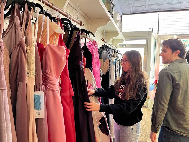 Elk Rapids High School Eco Club members Kaylee Lemmien and Gabe Klein look at donated and consigned dresses during the second day of Sustainable Style, an event they put on with Tinker Tailor and Green Elk Rapids. Feb 17, 2024.