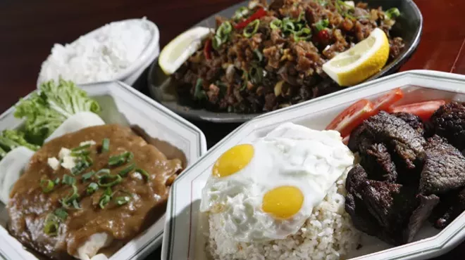 Lumpia sariwa (fresh vegetable eggroll topped with peanut garlic sauce), left, sisig (crispy pork with ginger sauce on sizzling hot plate), upper right, and tap-silog (marinated sirloin with garlic fried rice topped with fried eggs), front, from New Lutong Pinoy in Madison Heights