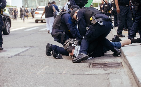 Police detain an antiwar protester in Detroit on Sunday.