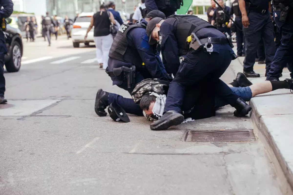 Image: Police detain an antiwar protester in Detroit on Sunday.