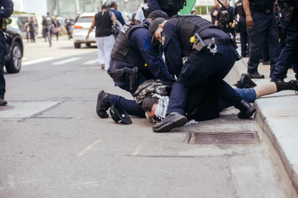 Police detain an antiwar protester in Detroit on Sunday.