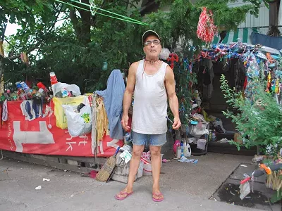 Migo stands in front of his home art exhibit.