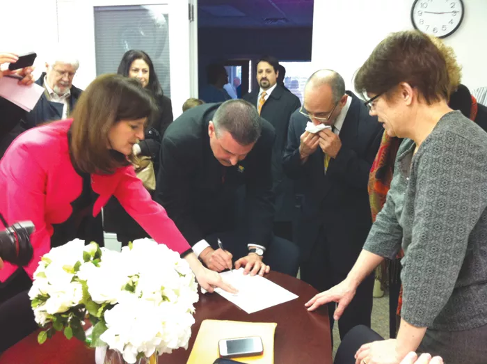 James Ryder, 48, and Frank Colasonti, 61, the first same-sex couple married at Oakland County Circuit Court Saturday, March 22, make it official with County Clerk Lisa Brown and their two witnesses, Jan Stevenson, publisher of Between the Lines, and Susan Horowitz. - Photo by Ryan Felton.